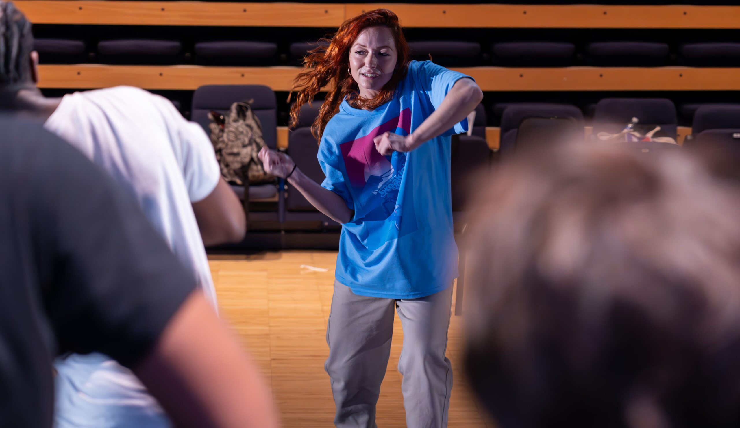 Female dance teacher leading a hip hop dance workshop.